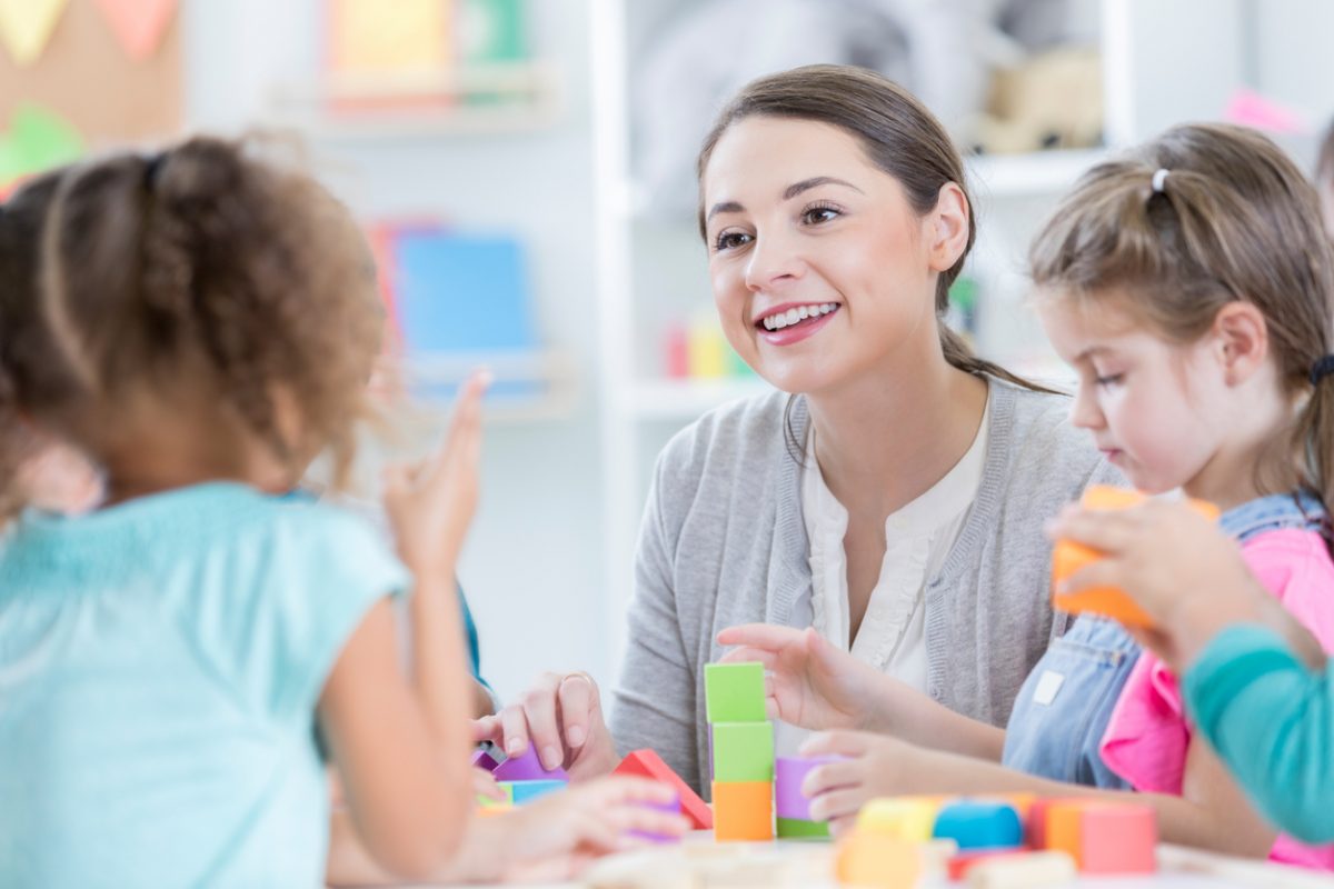 Childcare worker talks to children.