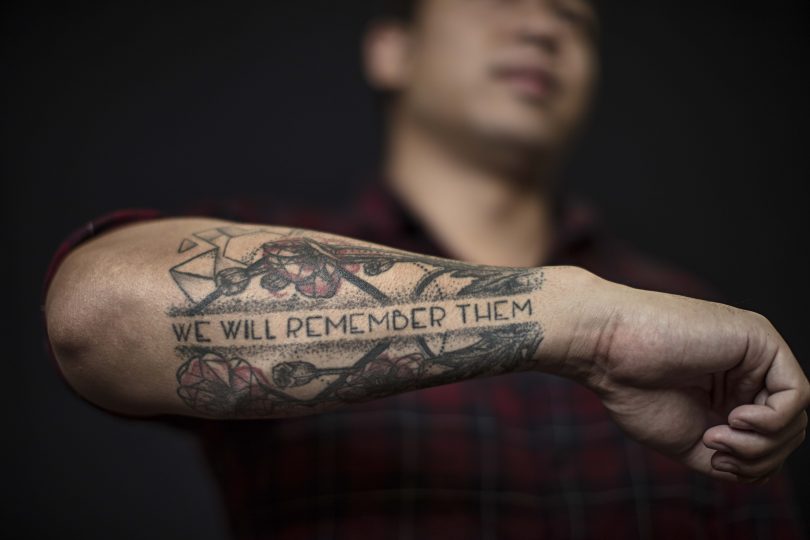Veteran displaying "we will remember them" tattoo on forearm.