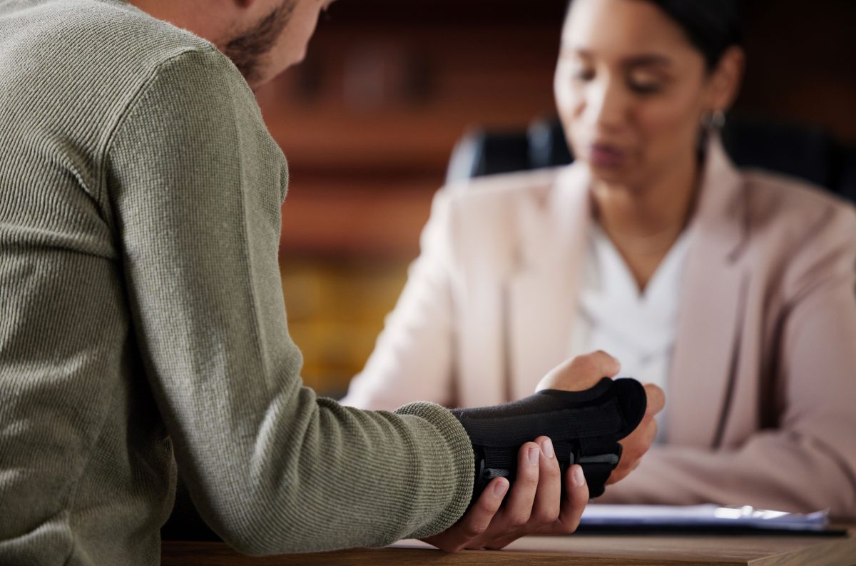 man with hand injury sitting with lawyer