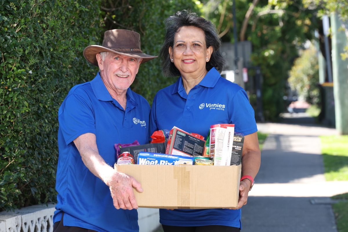 Vinnies volunteers hold a hamper of food