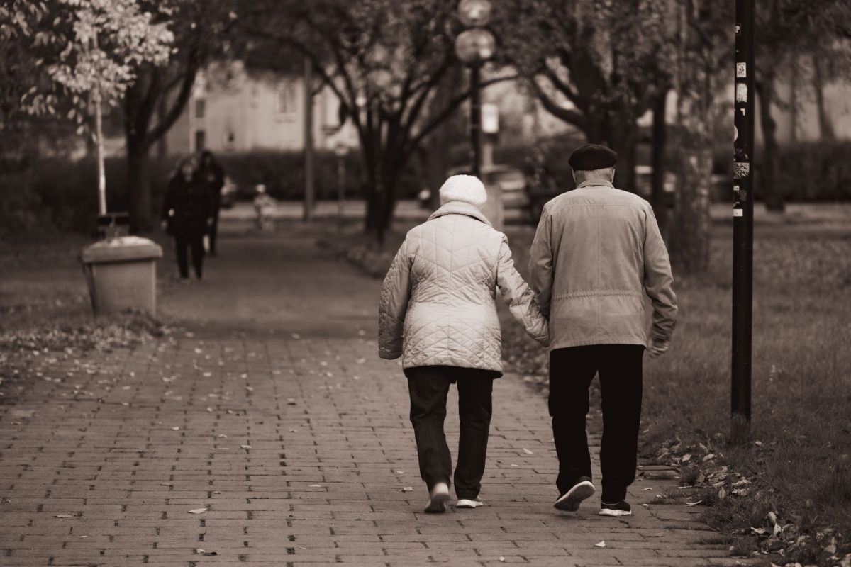Old couple walking and holding hands.