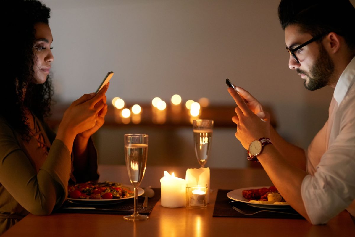 Even a romantic dinner is no match for the lure of a mobile phone. 