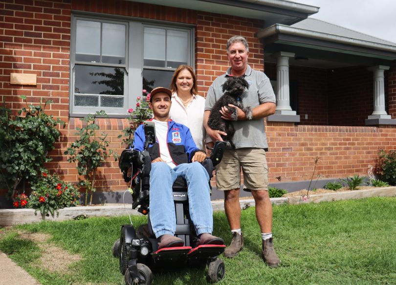 Bradley, Emily and Matt Hayes with puppy Jimmy in house front yard.