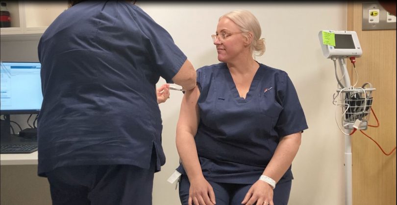 Registered nurse Rebecca Deveraux receiving COVID-19 vaccination.