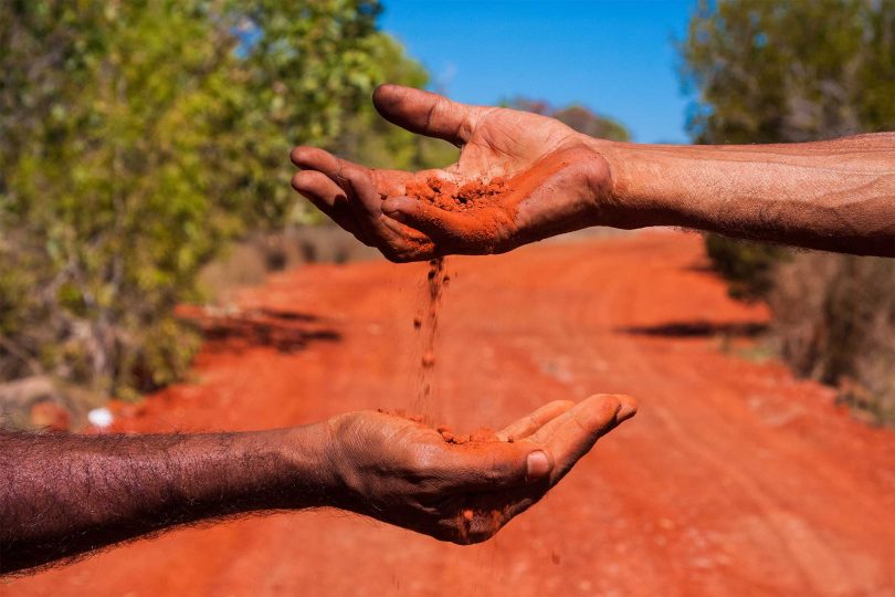 Two hands exchanging soil