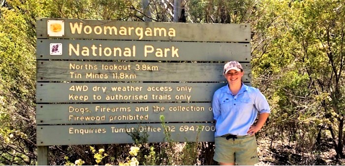 WIRES volunteer Mikayla Green standing in front of a sign for Woomargama National Park