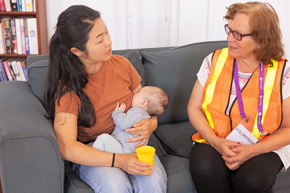 Mother breastfeeding with emergency volunteer