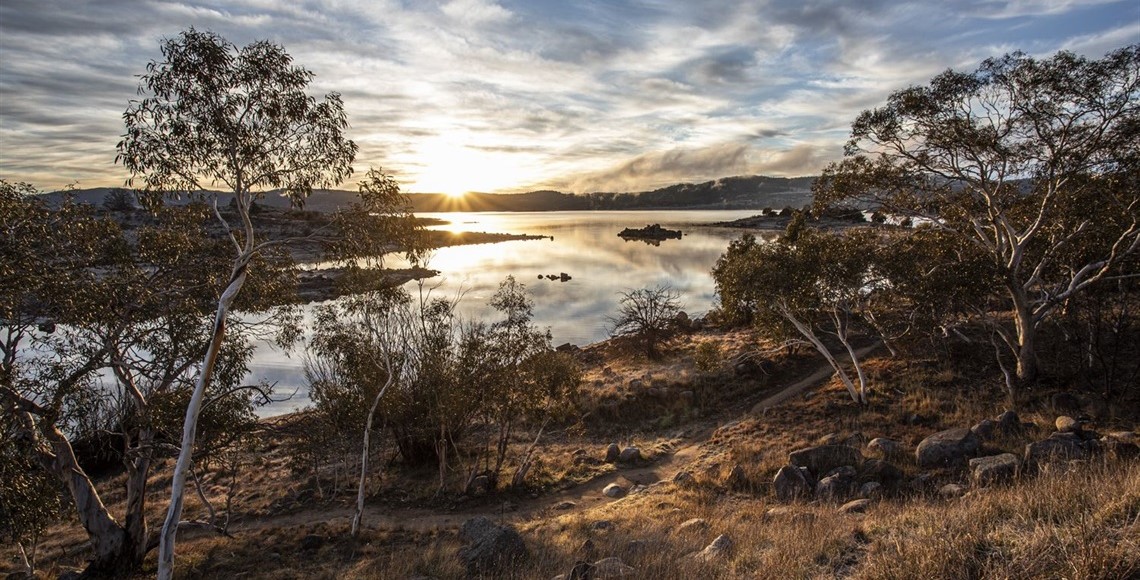 lake with the sun setting over the horizon