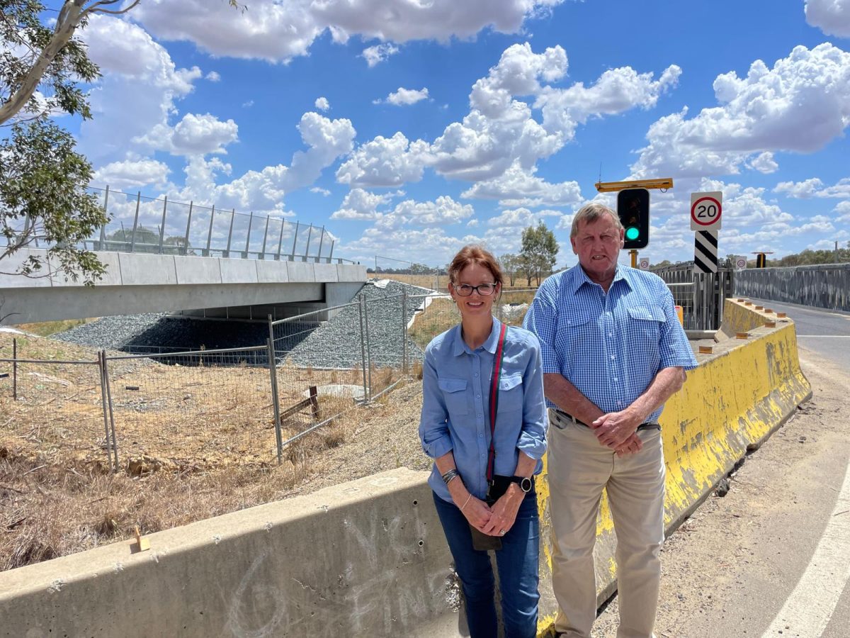 Member for Cootamundra Steph Cooke with Cootamundra-Gundagai Regional Council's mayor Abb McAllister on the site of the temporary road-over-rail bridge, with the new permanent bridge shown in the background.