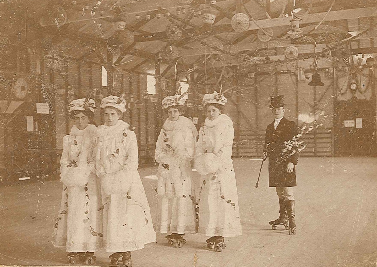 Historical photo of Victorian women and a man on roller skates.