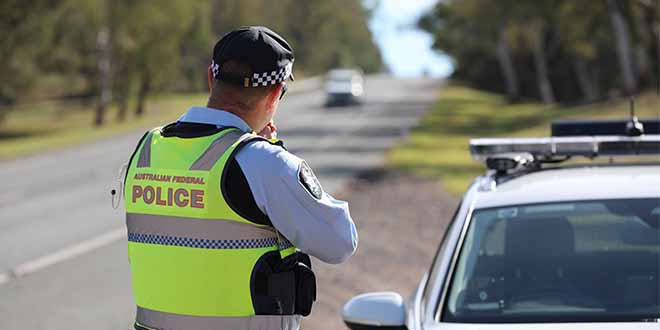 An Australian Federal Police officer checks the speed of motorists.