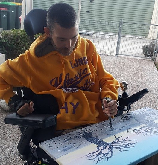 man in wheelchair painting