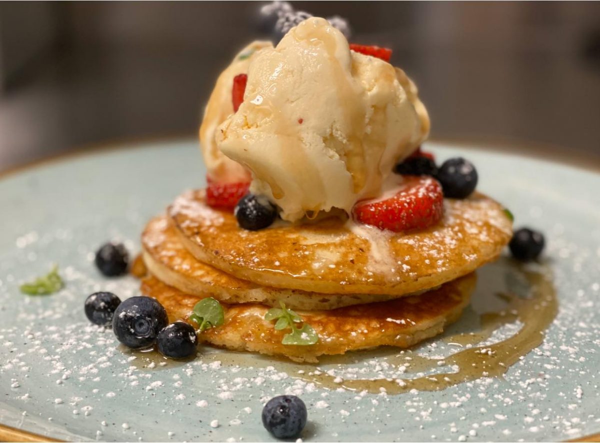 Hotcakes with ice cream, berries and syrup