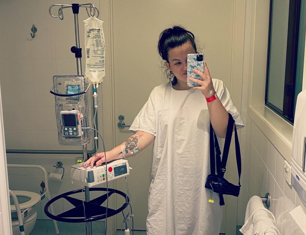 Woman in hospital gown connected to a drip