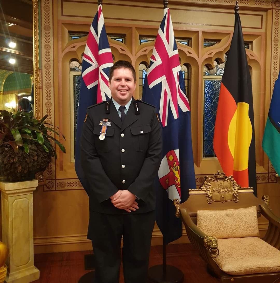 SES commander in uniform in front of flags