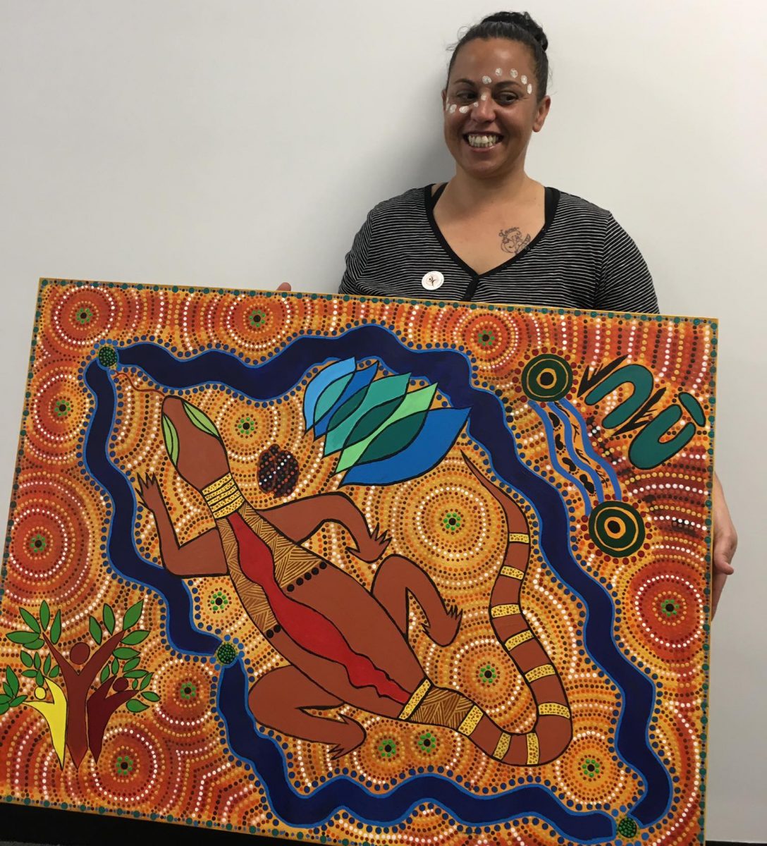 Wagga local artist Jasmine Williams holding one of her paintings
