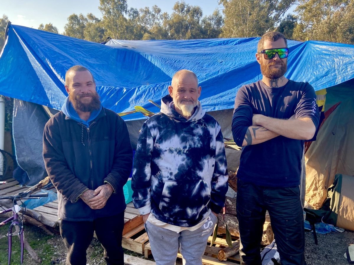 Homeless camp with three men