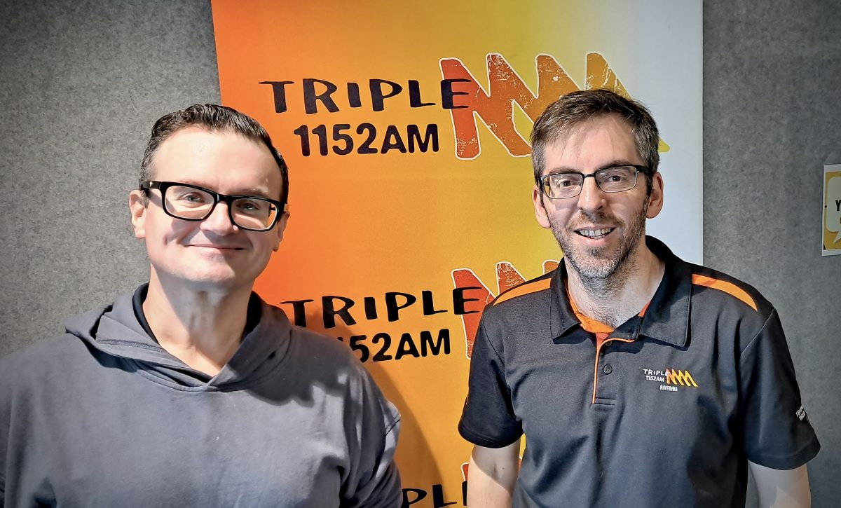 Radio hosts Jamie Way and Leigh Ryan in front of a Triple M radio sign
