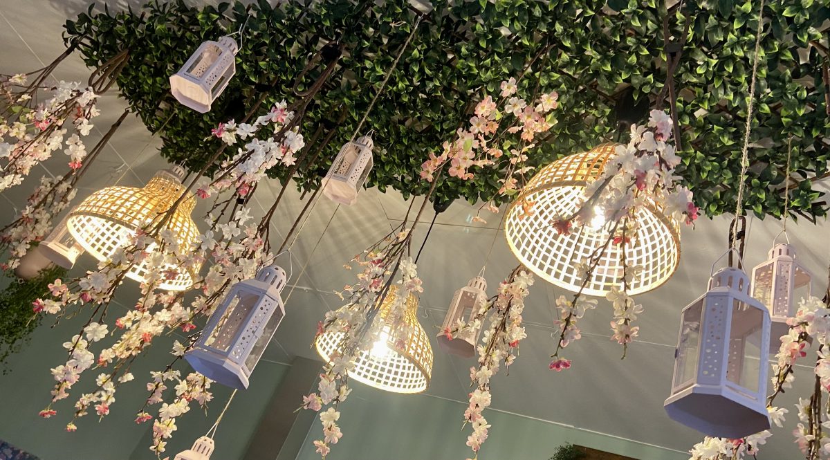 Lights and florals hanging from a ceiling feature