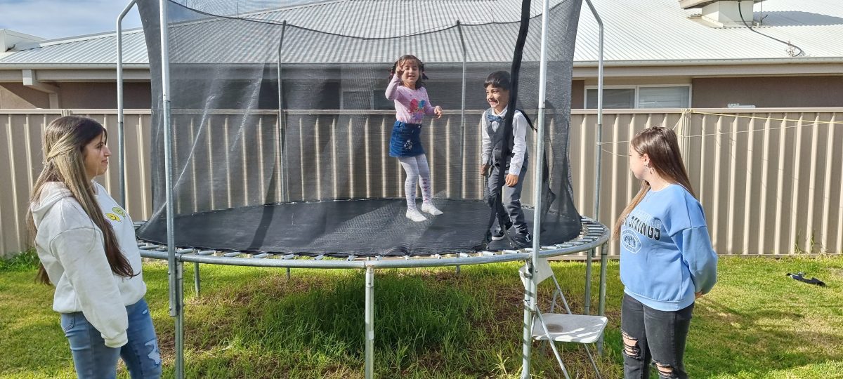 Kids on and around a trampoline