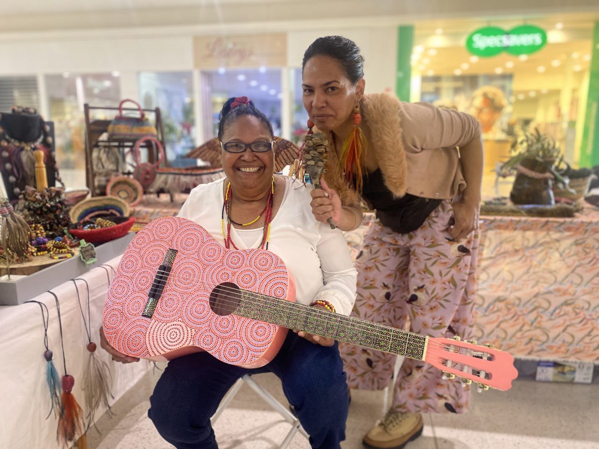 Bertha and Angela Firebrace pretend to sing at Griffith Central Market