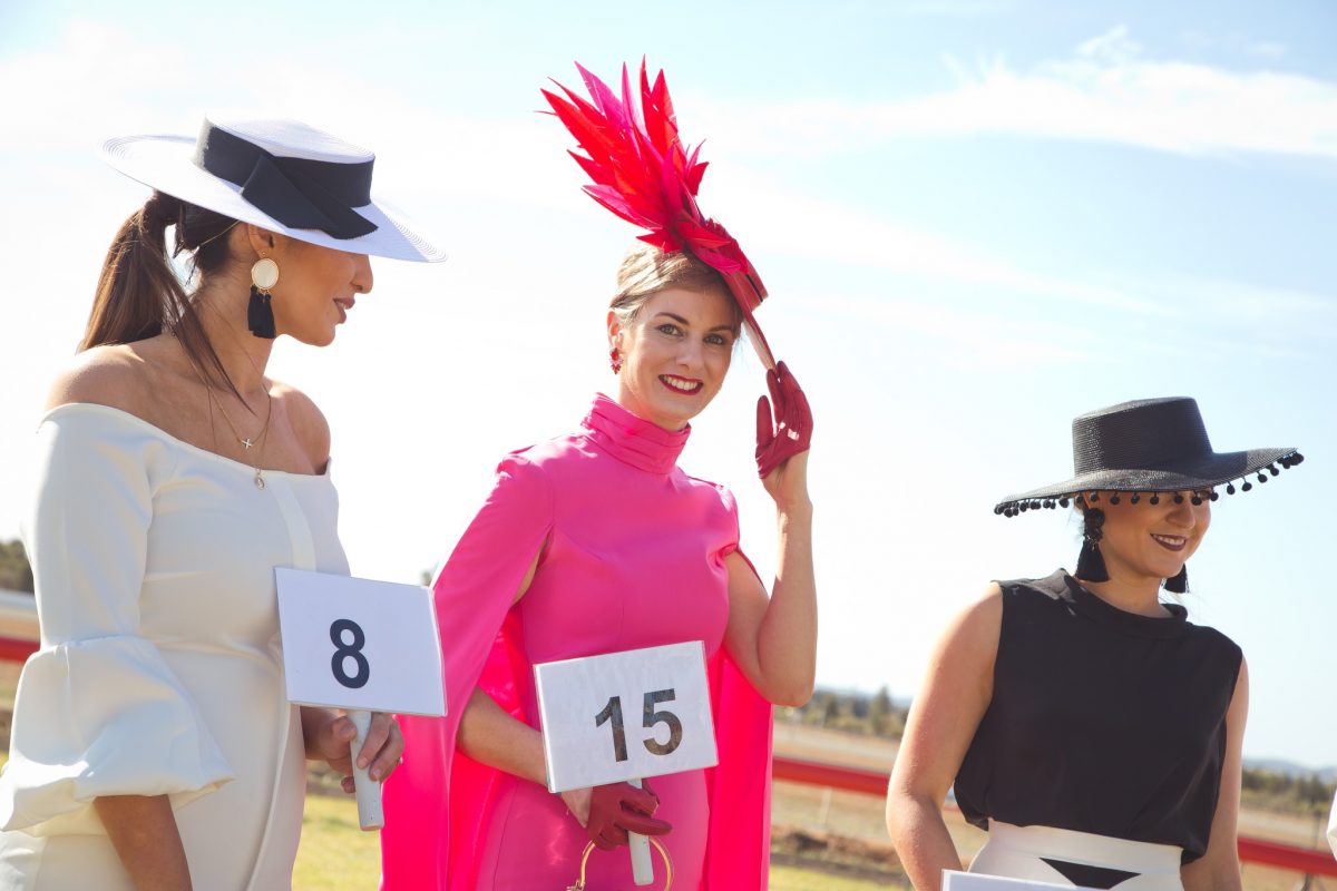Three women in racecourse attire 