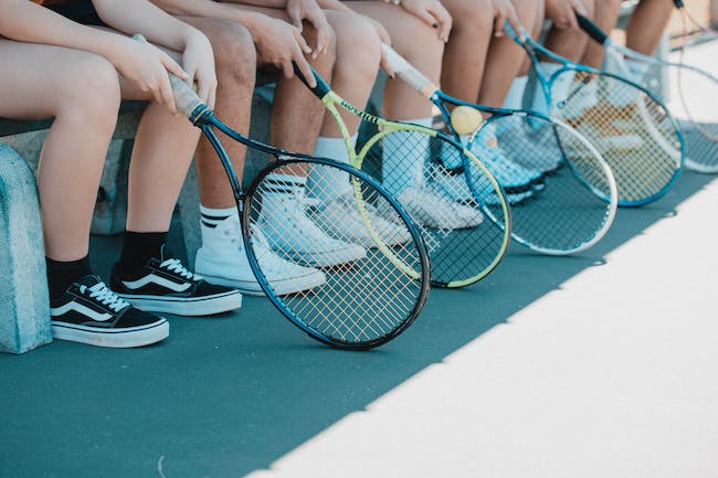 Legs and tennis rackets lined up