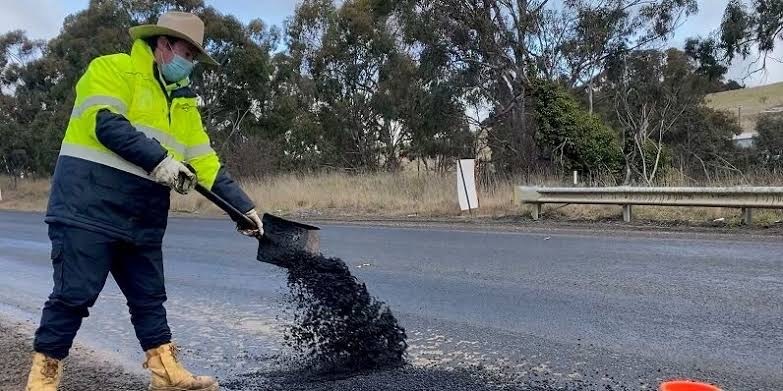 man fixing pothole