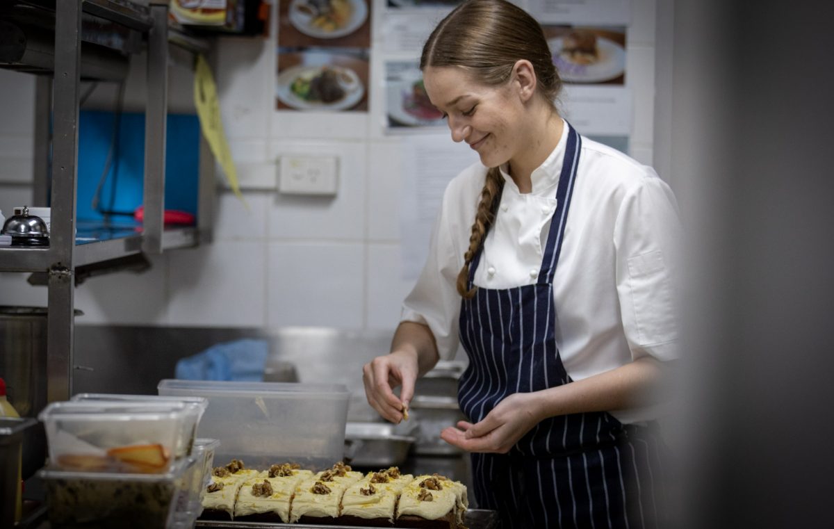 Wagga RSL chef apprentice Mackenzie Mitchell dressing slices of carrot cake