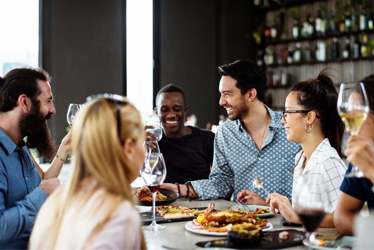 a group of people eating food around a restaurant table