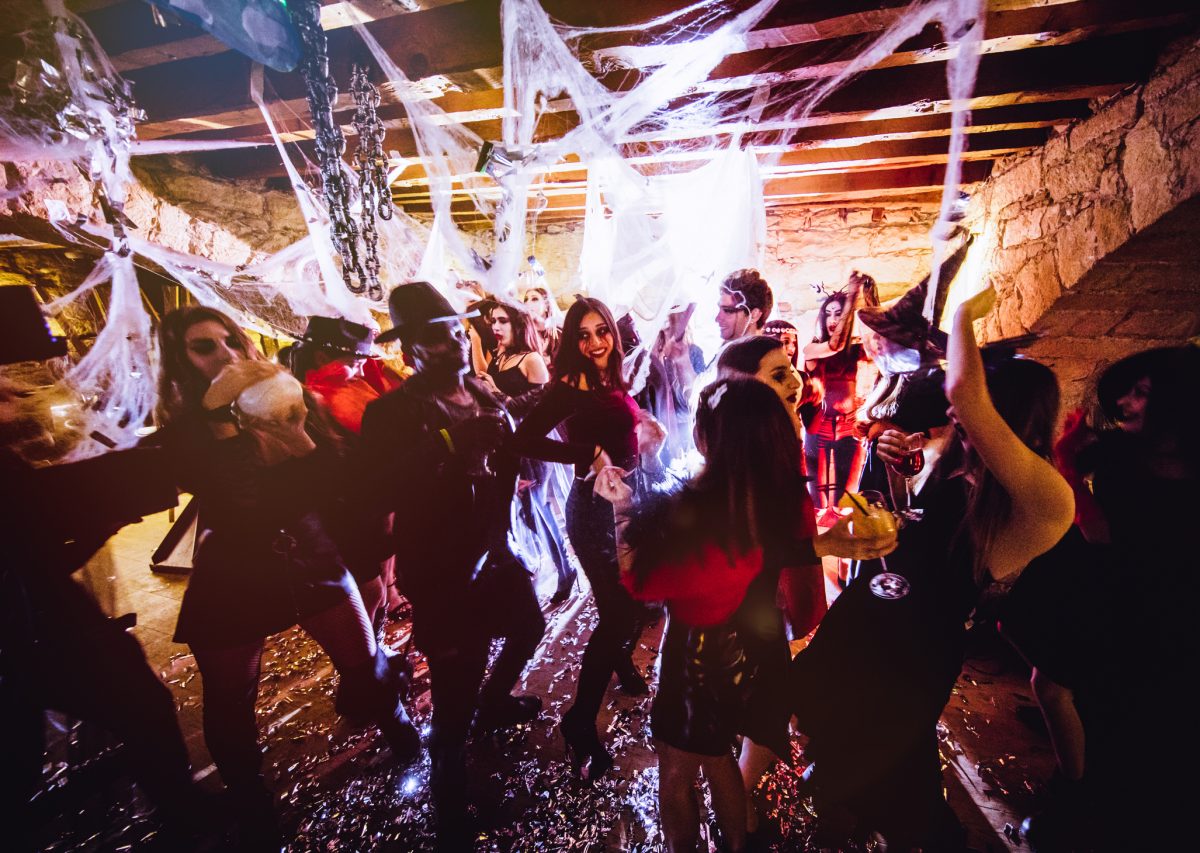 People in spooky costumes on a dance floor at a Halloween party