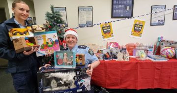 Santa's helpers dressed in blue are helping him out with delivering toys