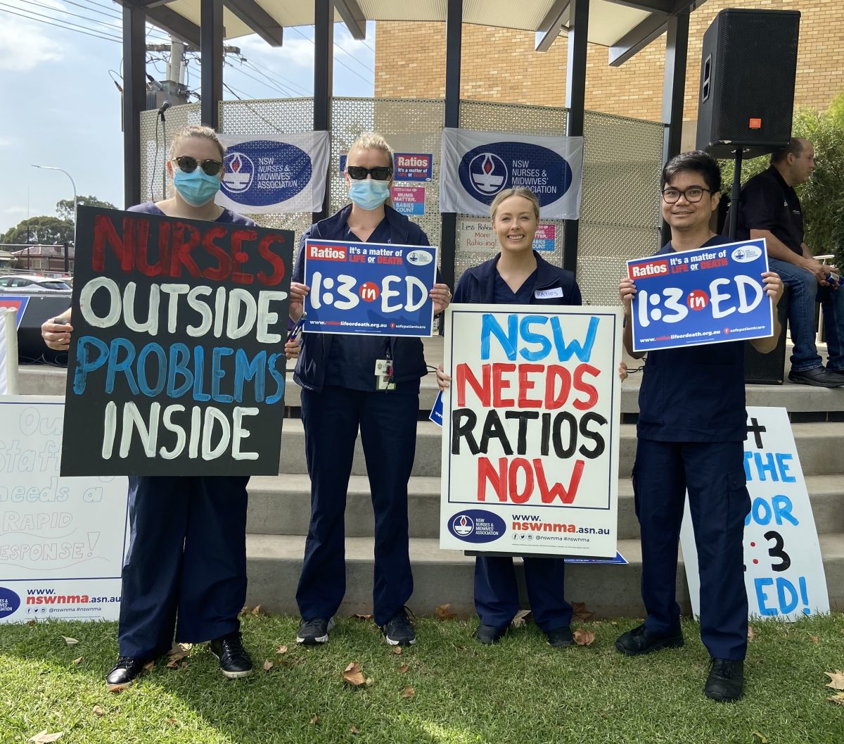 Four nurses hold placards.