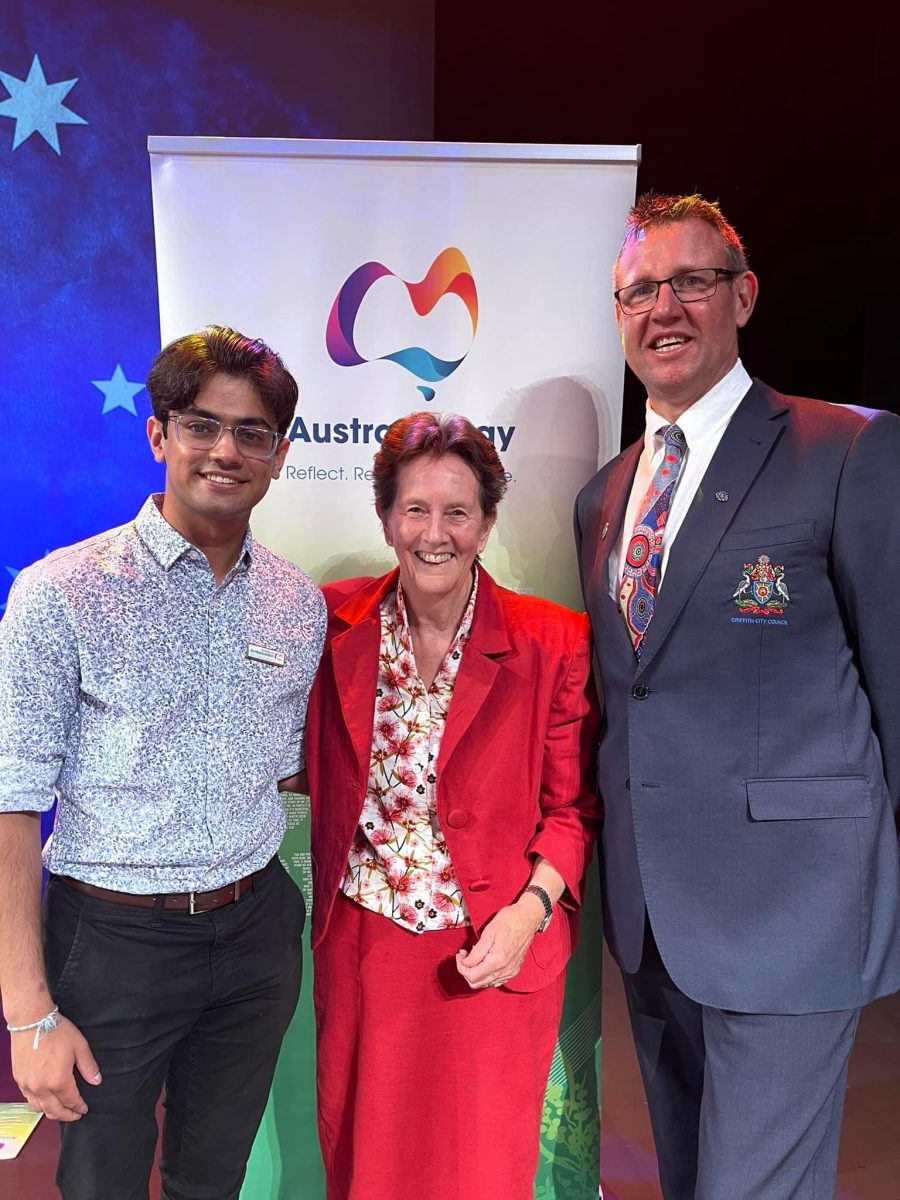 Australia Day Ambassador Khushaal Vyas with Sister Patricia Johnson and Griffith mayor Doug Curran on the podium 