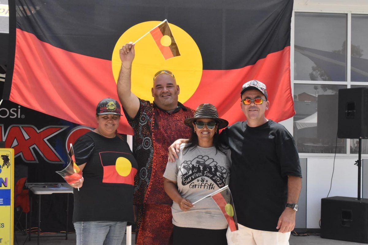 A group of Land Council members waving the Aboriginal flag