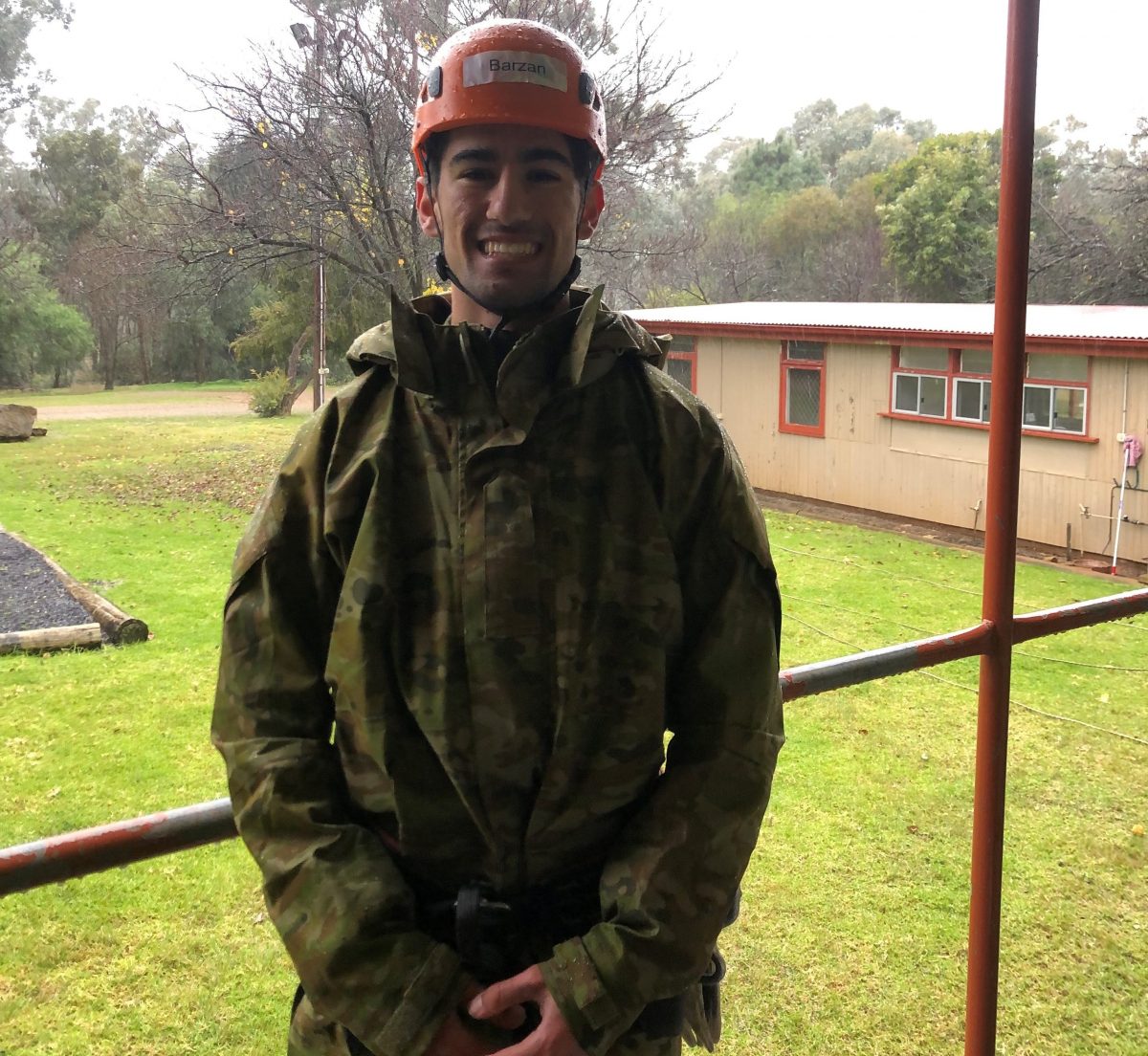 Mount Austin High School student Barzan Smoqi in camouflage gear and an orange helmet