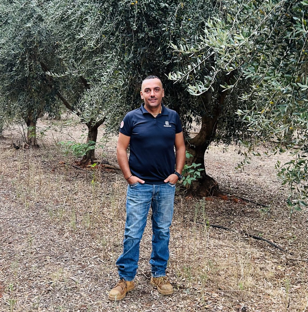 Dr Ruffolo in front of olive trees