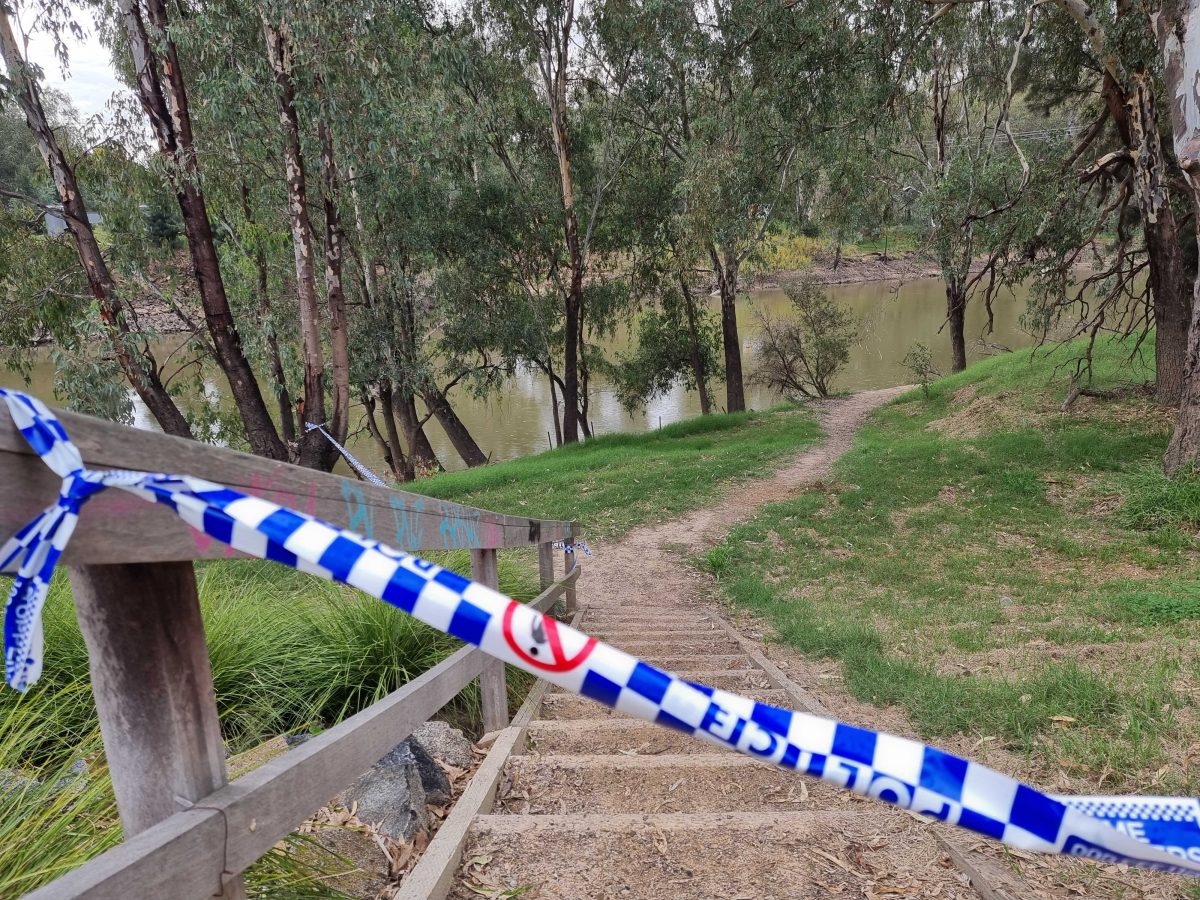 Police tape on path to river