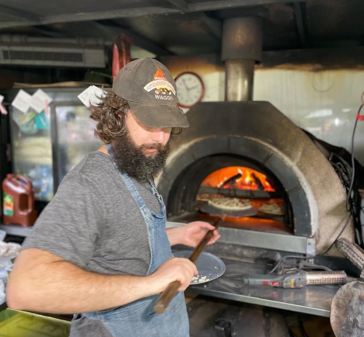 man and woodfire oven