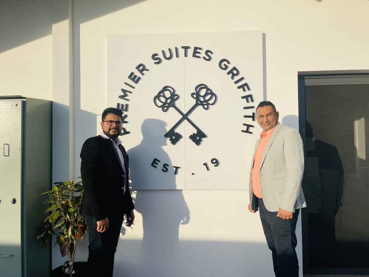 Pinkal Patel and Yogesh Bhatt in front of hotel sign