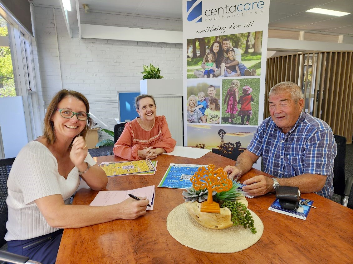 Centracare employees with John Harper on a table 