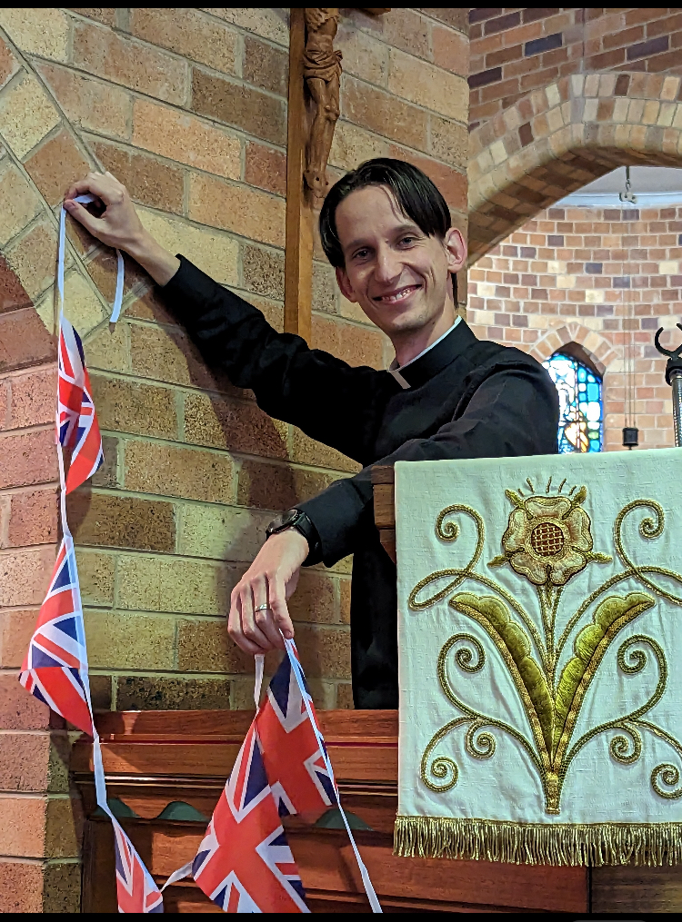 priest hanging up British flags