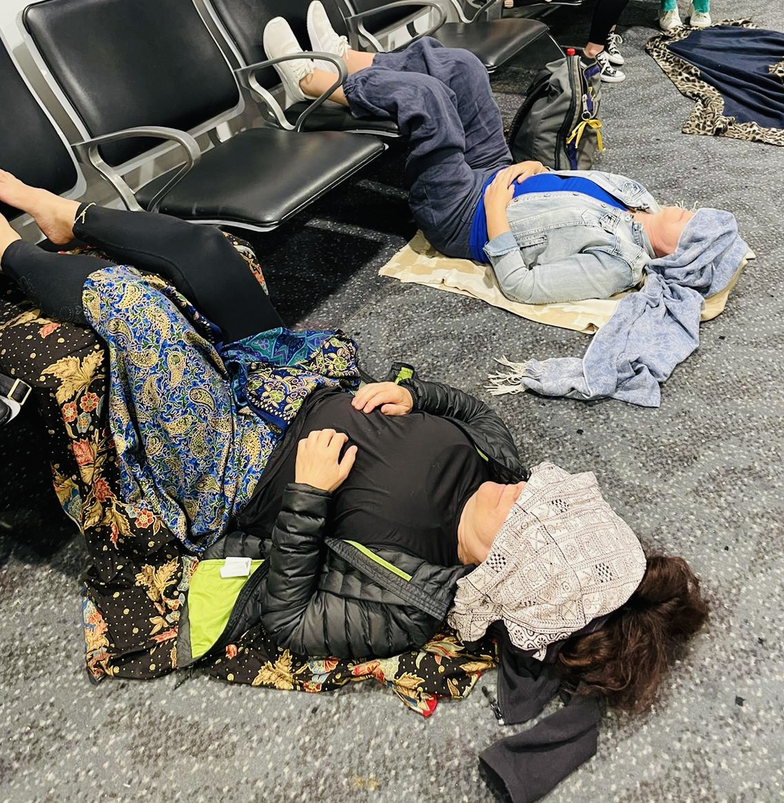 Two women doing yoga in the airport 