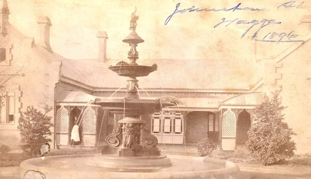 old photo of fountain in front of hospital building