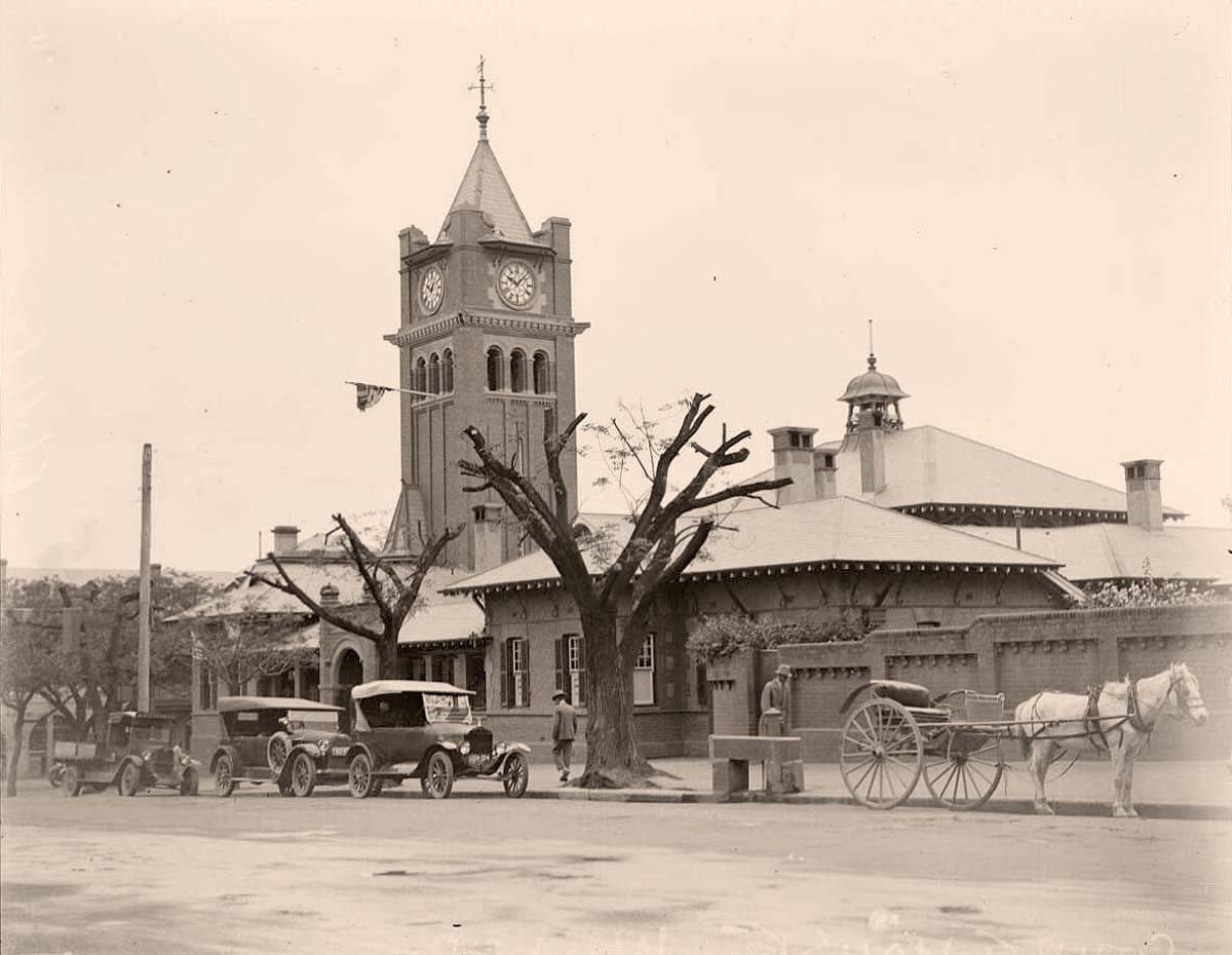 Cars with a horse and buggy parked in front of the courthouse in 1925