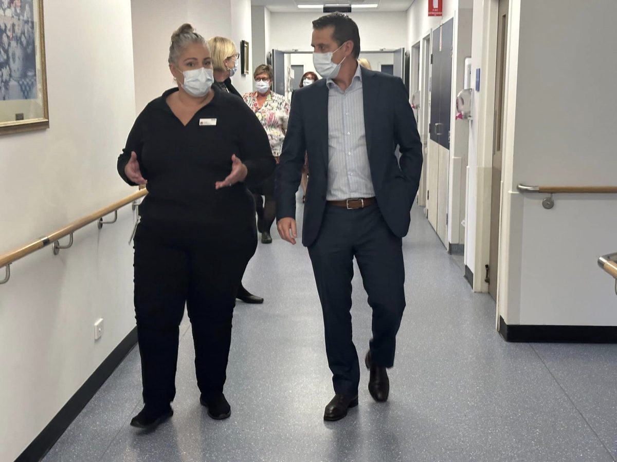 woman and man walking along hospital corridor