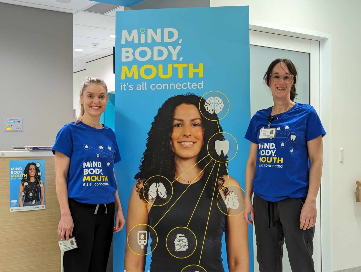 two female dental clinic staff with poster