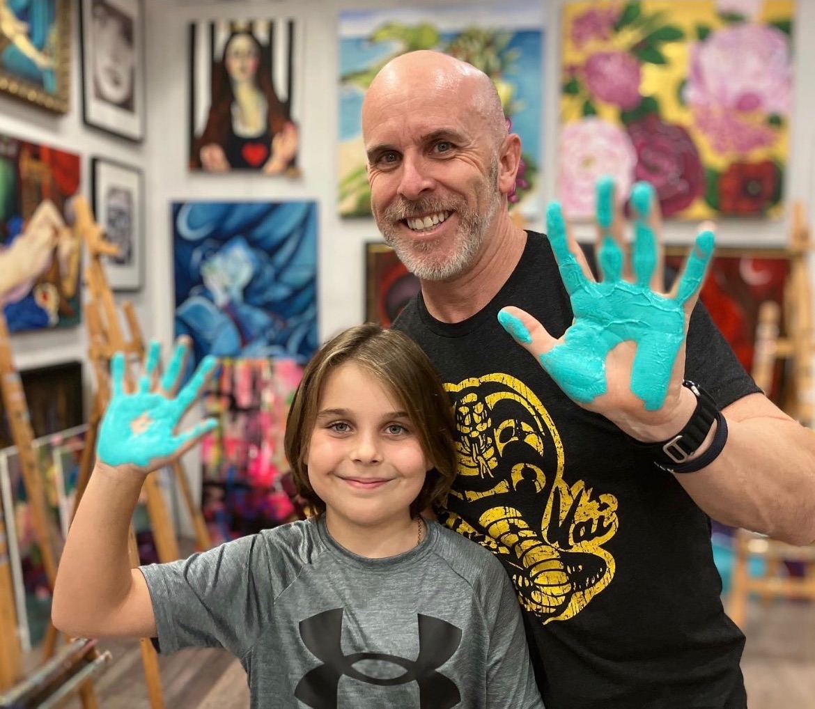 Wagga Motors Scott Braid and his son at Tahlia Keogh fine art gallery with blue paint on their hands