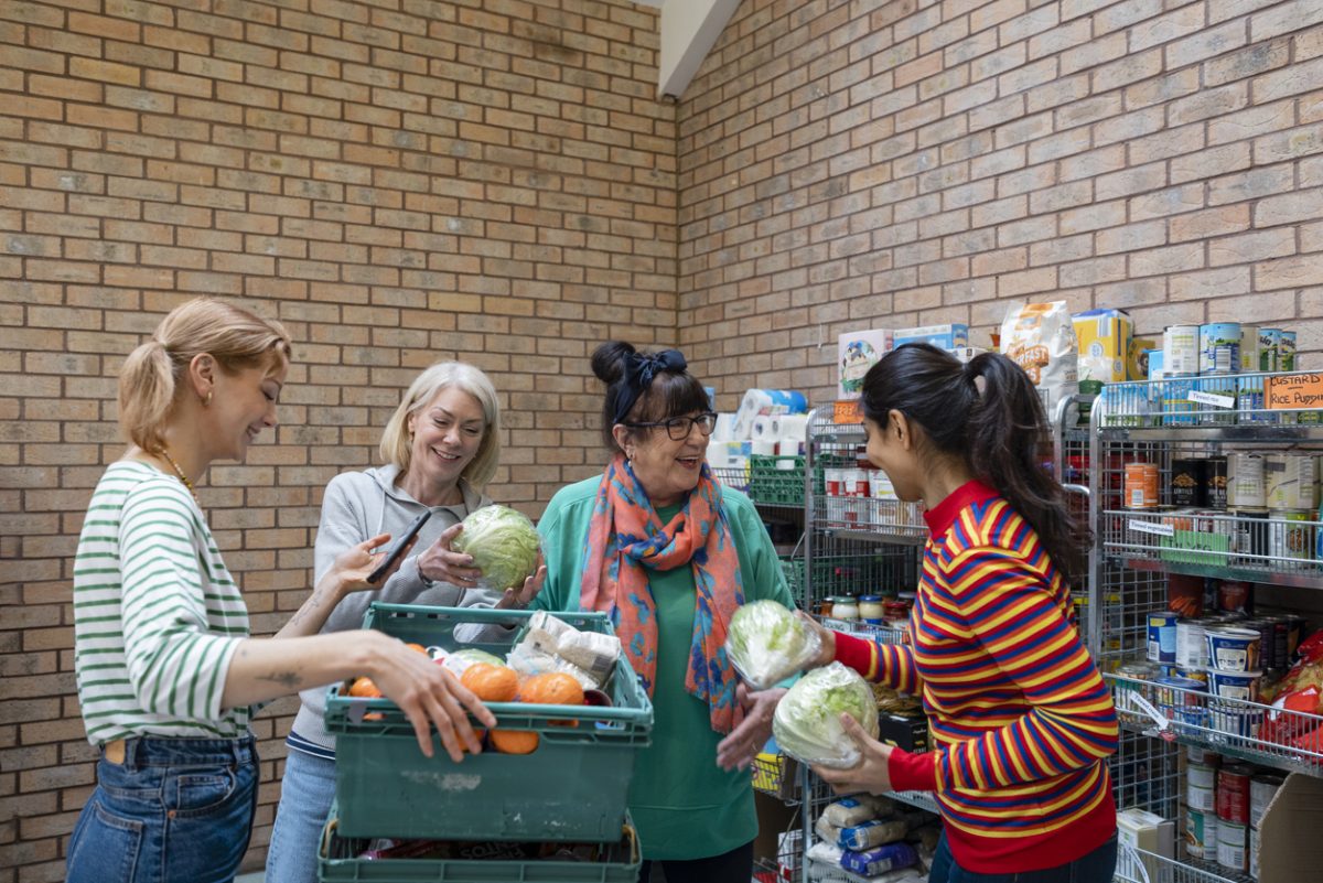 four female volunteers sorting food at a food bank