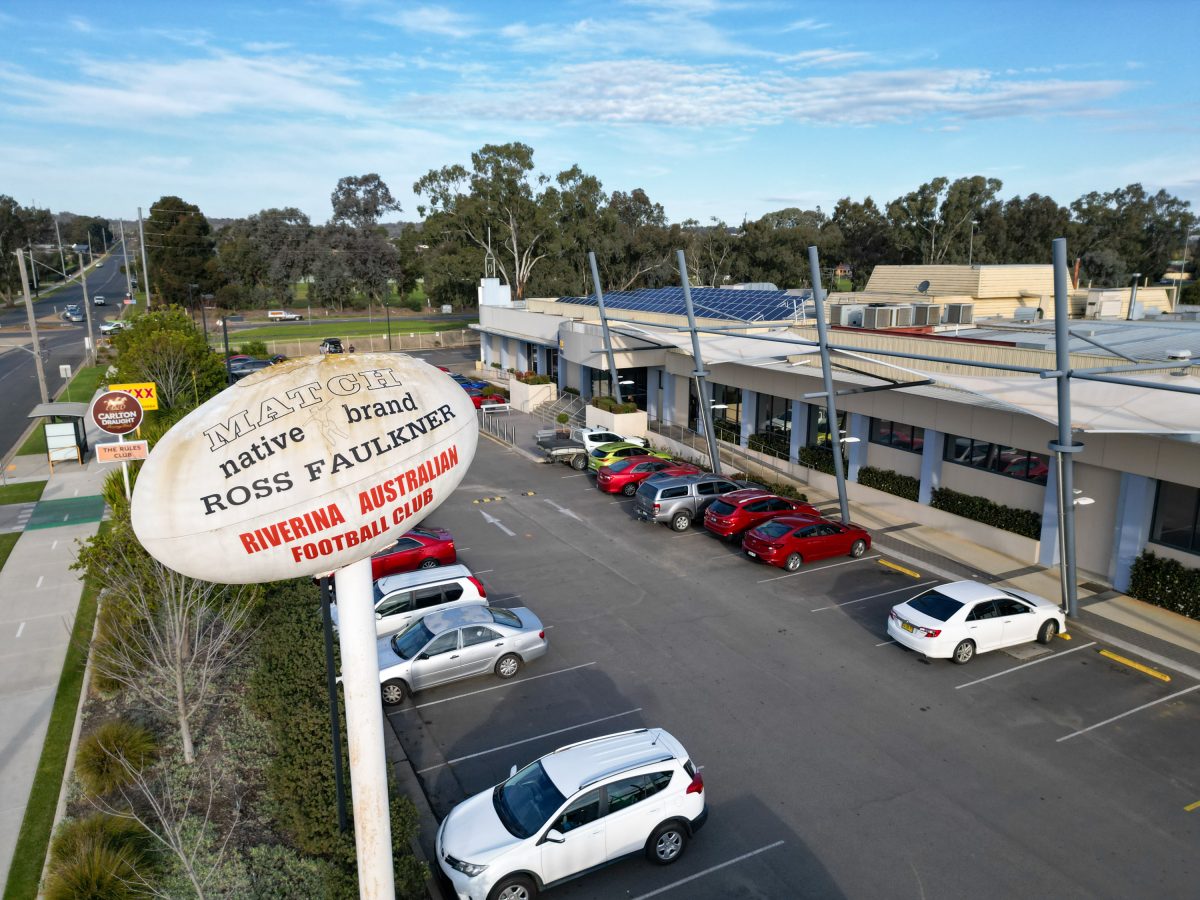 The front carpark and entrance of the Rules Club, with its AFL ball statue positioned on top of a pole to the left hand side.